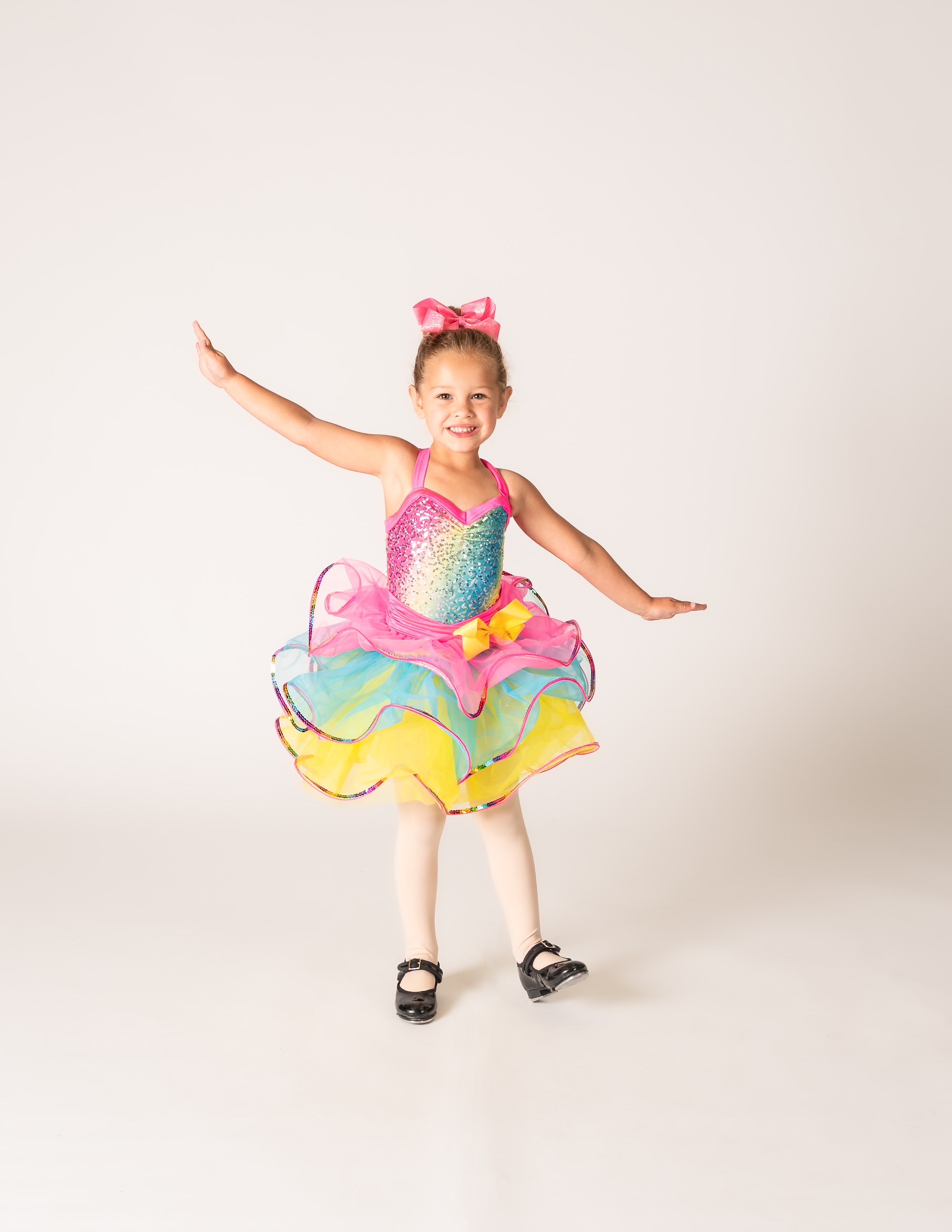 Two and three year old dancer in a rainbow tutu and tap shoes