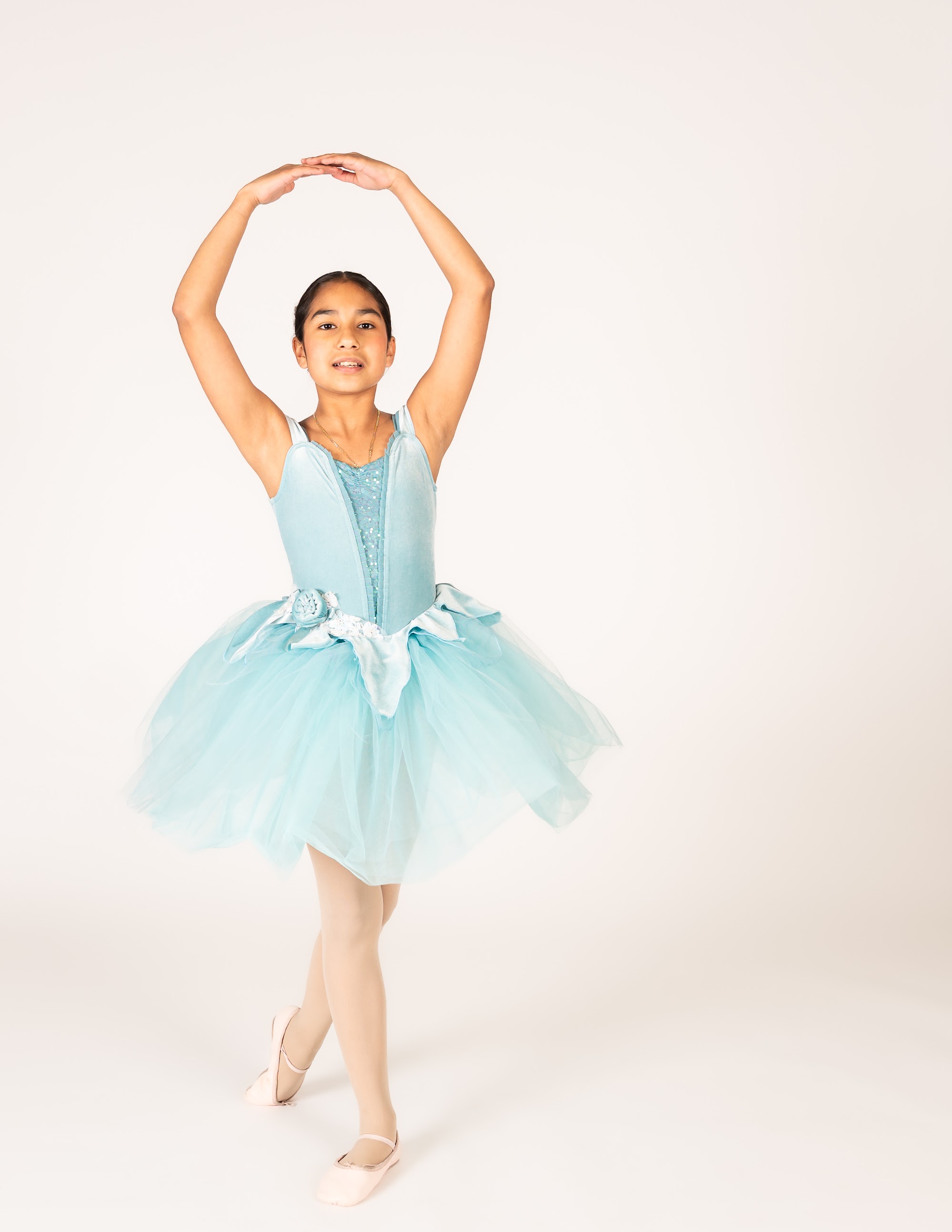 Ballet II dancer in an aqua tutu with arms en haut