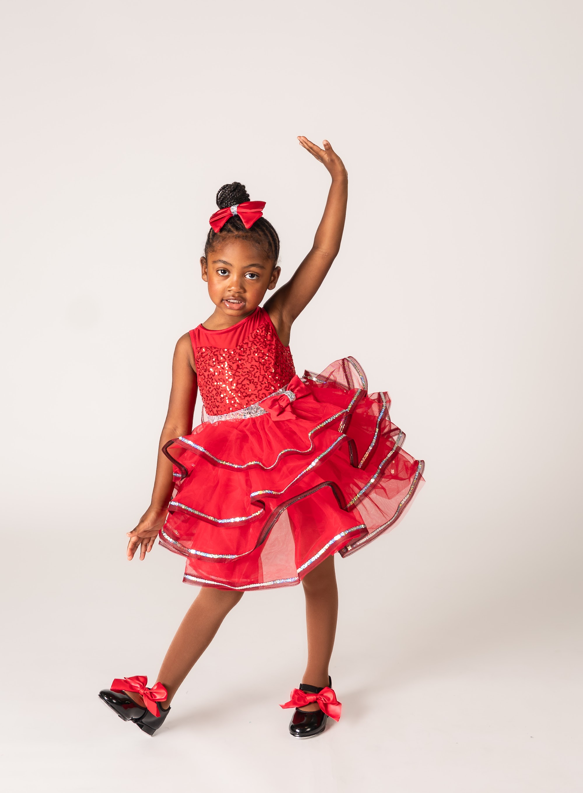 Dancer in a red ruffled costume posing in tap shoes