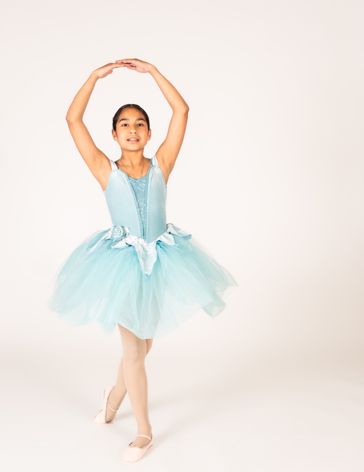 Ballet II dancer in an aqua tutu with arms en haut
