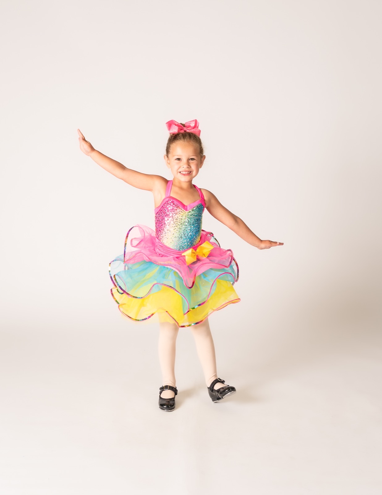 Two and three year old dancer in a rainbow tutu and tap shoes