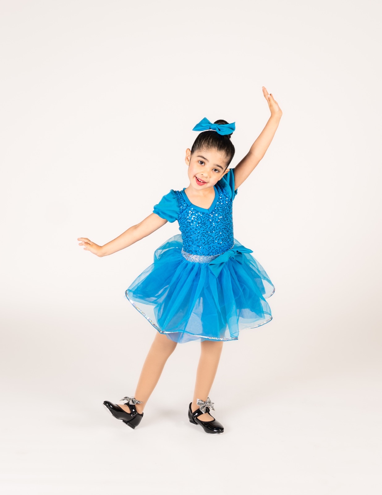 Four and five year old dancer in a bright blue tutu and tap shoes