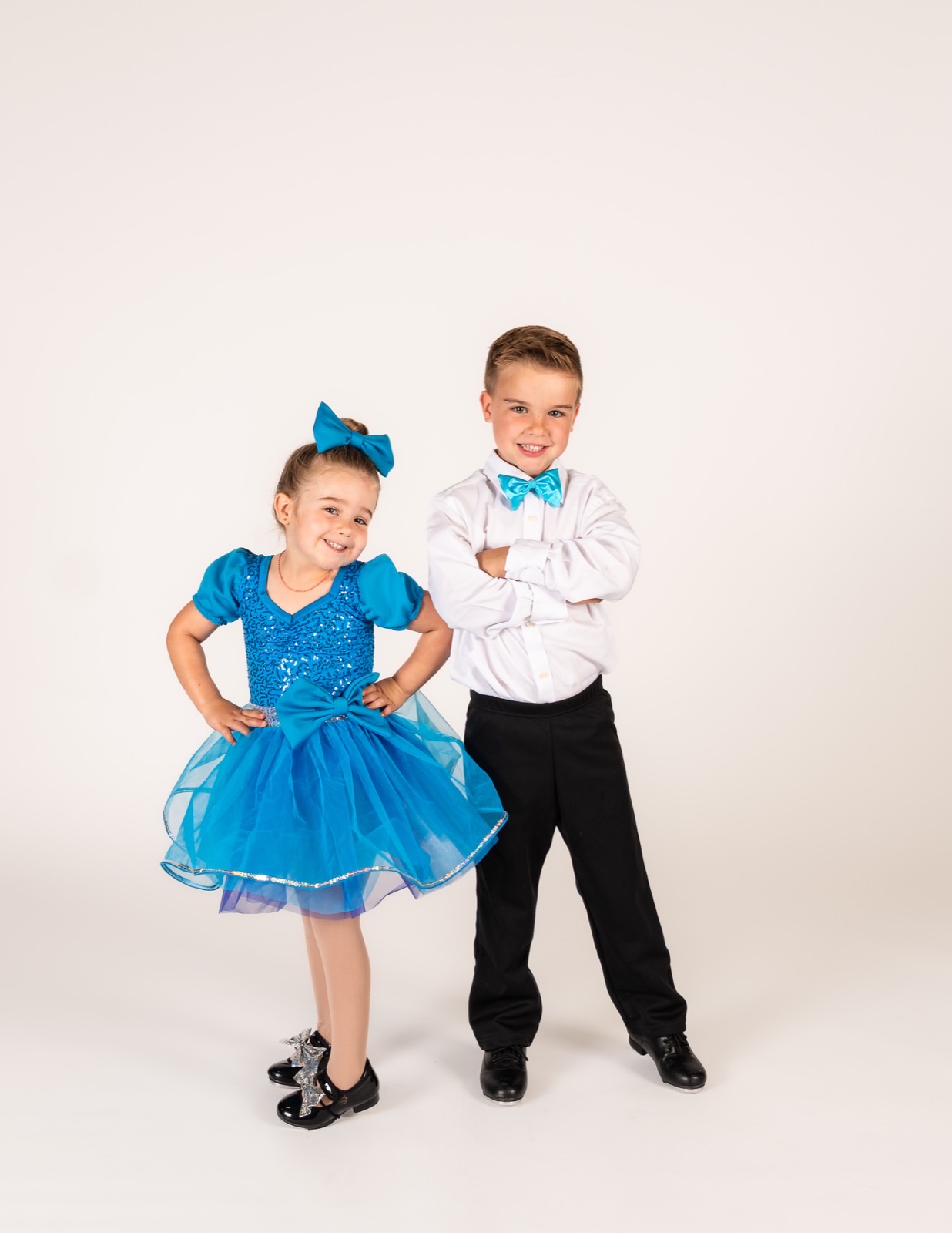Four and five year old dancers, a girl in a blue tutu and a boy in tap shoes